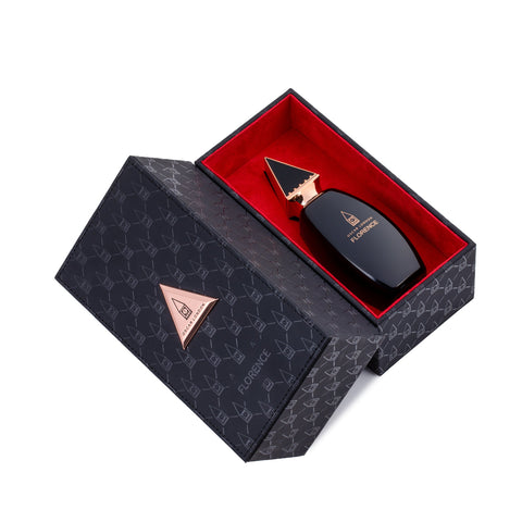 Luxury Florence perfume packaging featuring a black and gold fragrance bottle from the Oscar London Big Ben Collection. The bottle has a sleek, modern design with a pointed gold cap and is elegantly placed inside a black box with a geometric pattern and rose gold accents. The box's interior is lined with rich red velvet for a premium presentation.