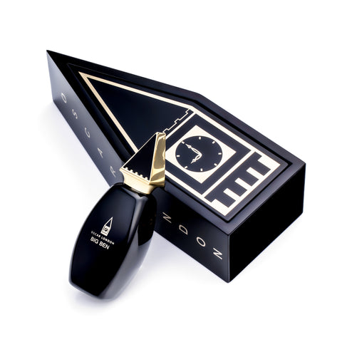 Exclusive Oscar London Big Ben perfume from the Big Ben Collection, presented in a striking black and gold box designed to resemble the iconic Big Ben clock tower. The sleek black bottle, featuring a distinctive gold triangular cap inspired by the tower’s architecture, stands beside the custom-shaped packaging. The luxurious and collectible design enhances the fragrance’s sophisticated appeal.